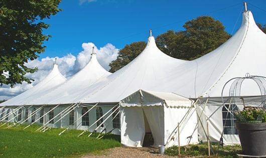 tall green portable restrooms assembled at a music festival, contributing to an organized and sanitary environment for guests in Bowdoin ME